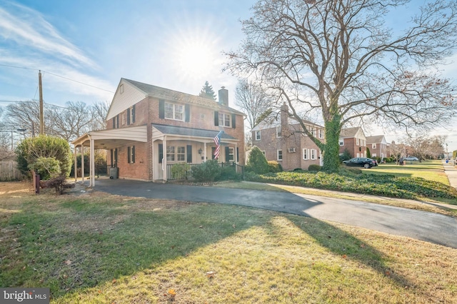 view of front of property with a front lawn and a carport