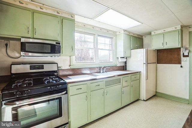 kitchen featuring green cabinets, a paneled ceiling, sink, and stainless steel appliances