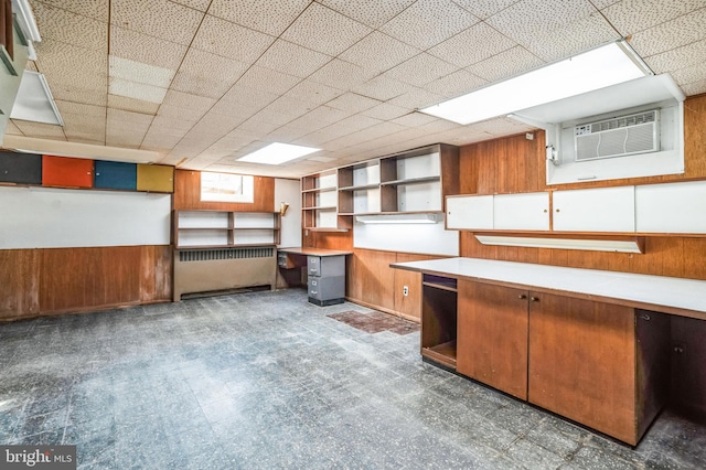 basement featuring a wall mounted AC and wood walls