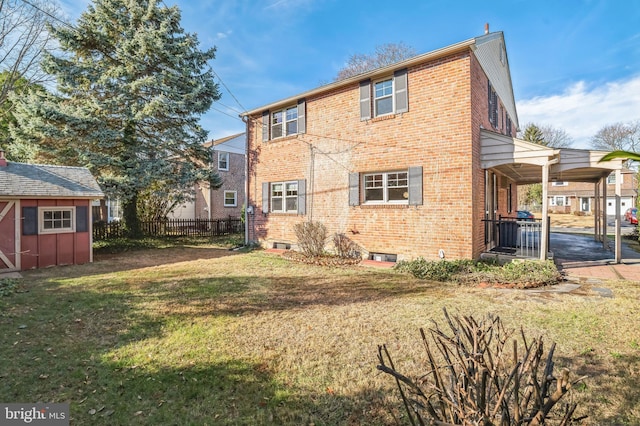 rear view of house featuring a yard and a storage shed