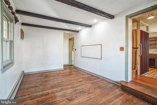 spare room featuring beam ceiling, hardwood / wood-style floors, and a baseboard heating unit