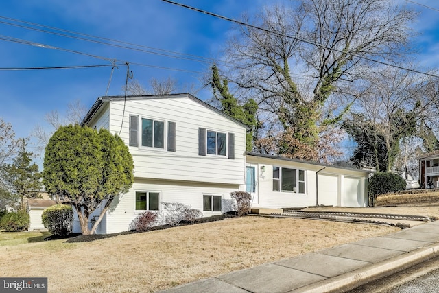 split level home featuring a garage and a front lawn