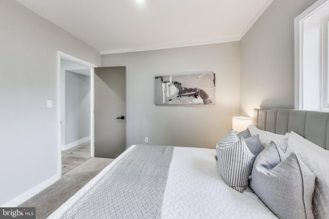 bedroom with light hardwood / wood-style flooring and crown molding