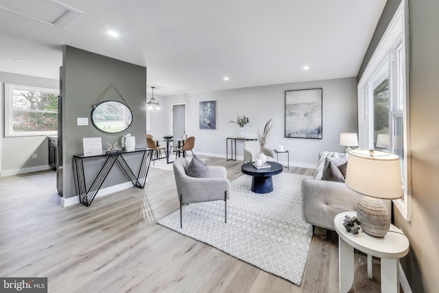 living room featuring light hardwood / wood-style flooring and a notable chandelier