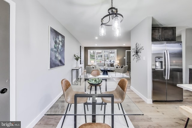 dining area featuring light hardwood / wood-style floors and an inviting chandelier