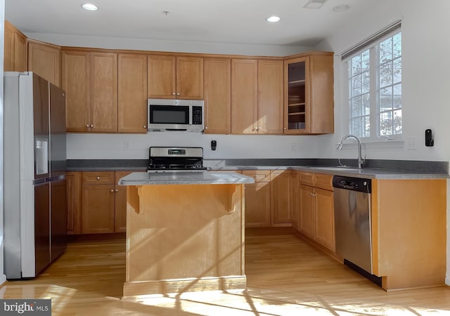 kitchen featuring a center island, sink, appliances with stainless steel finishes, and light hardwood / wood-style flooring