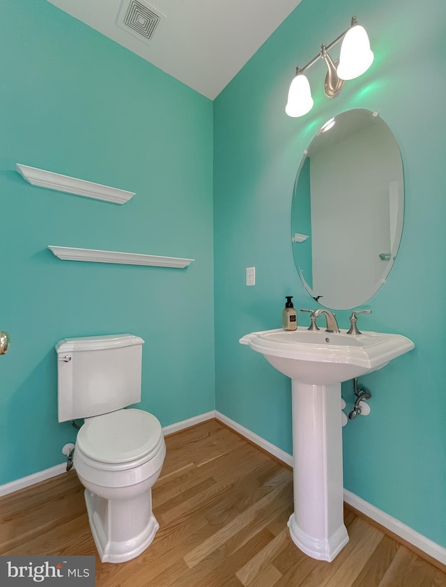 bathroom featuring hardwood / wood-style flooring and toilet