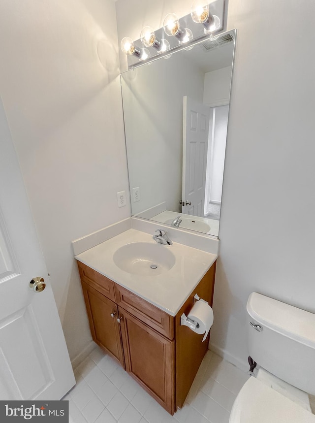 bathroom featuring tile patterned flooring, vanity, and toilet