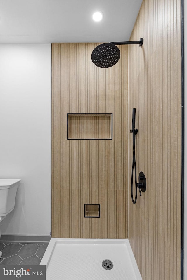 bathroom with a shower, tile patterned flooring, and toilet