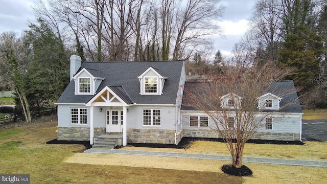 cape cod-style house featuring a front yard