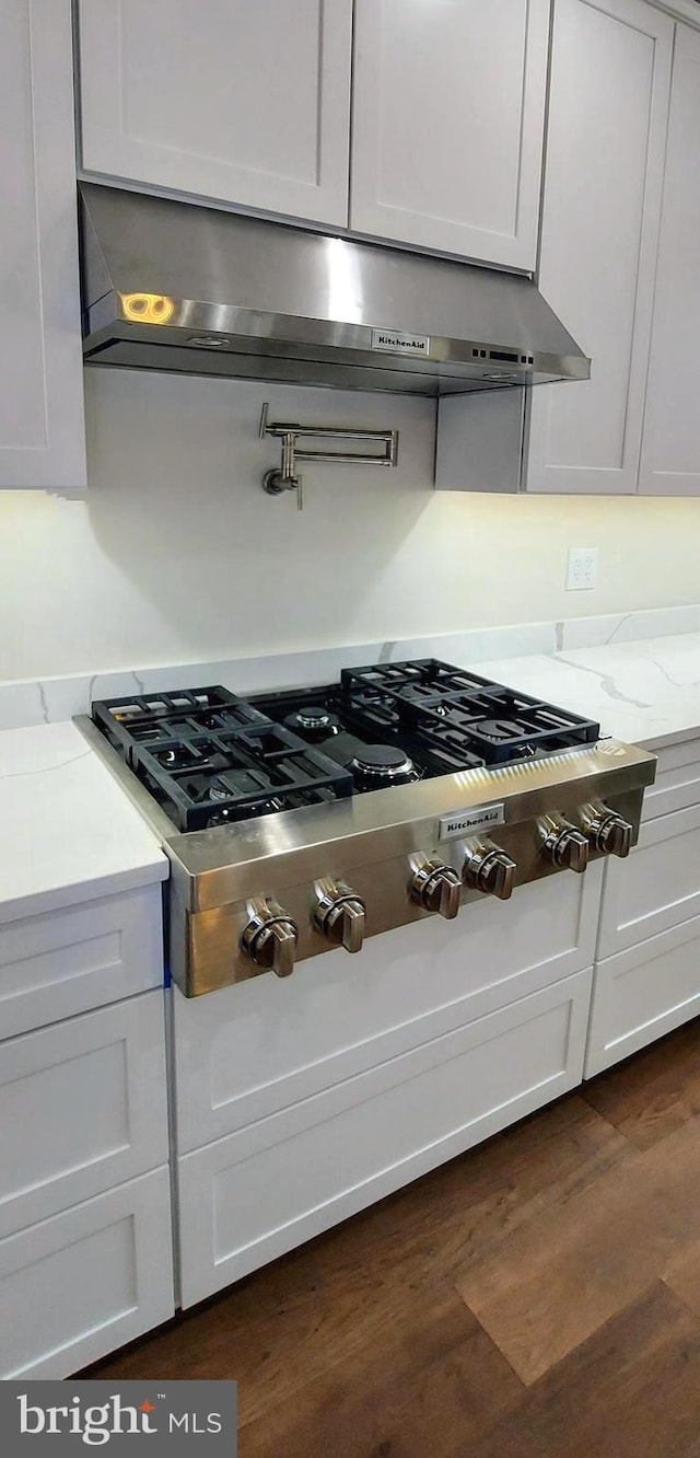 kitchen featuring dark hardwood / wood-style flooring, white cabinetry, and stainless steel gas cooktop