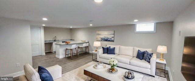 living room with light hardwood / wood-style flooring and sink