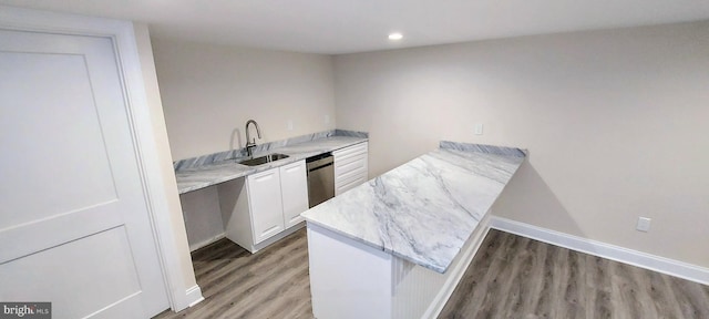 bar with dark hardwood / wood-style flooring, white cabinetry, stainless steel dishwasher, and sink