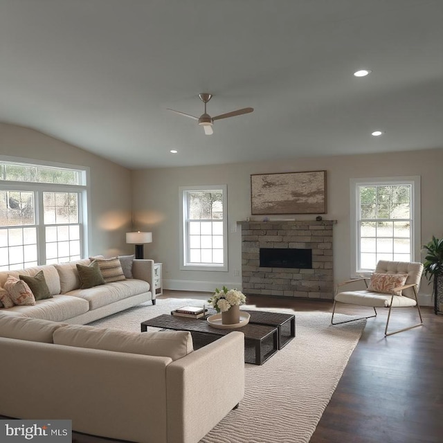 living room with dark hardwood / wood-style floors, ceiling fan, a stone fireplace, and lofted ceiling