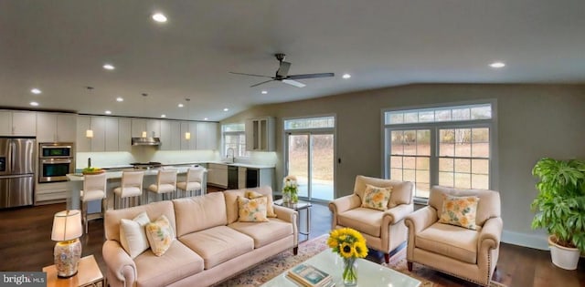 living room with vaulted ceiling, ceiling fan, dark wood-type flooring, and sink