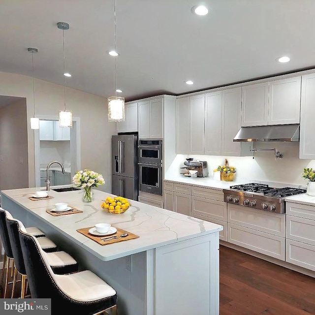 kitchen featuring sink, dark wood-type flooring, stainless steel appliances, decorative light fixtures, and white cabinets