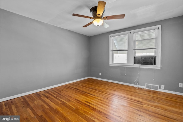 spare room featuring ceiling fan, cooling unit, and light wood-type flooring