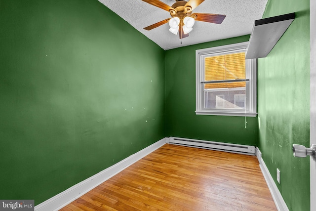 empty room featuring ceiling fan, a baseboard radiator, a textured ceiling, and light hardwood / wood-style floors