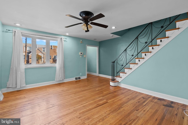 unfurnished living room featuring wood-type flooring and ceiling fan