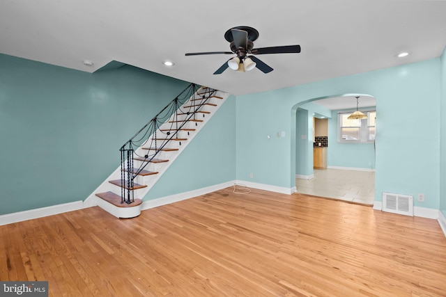 unfurnished living room with hardwood / wood-style flooring and ceiling fan