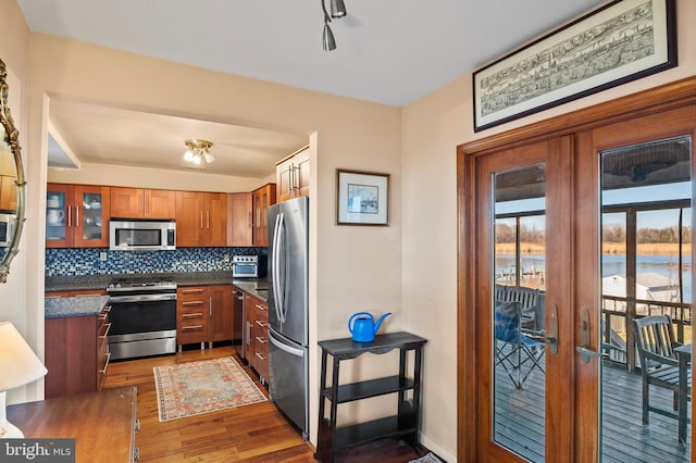 kitchen featuring tasteful backsplash, french doors, dark wood-type flooring, and appliances with stainless steel finishes