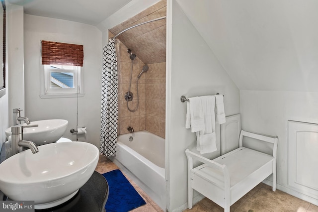 bathroom featuring sink, vaulted ceiling, and shower / tub combo with curtain