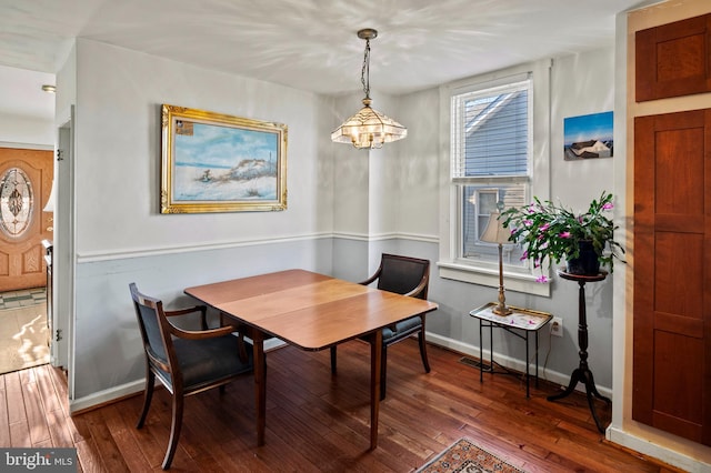 dining room with an inviting chandelier and dark wood-type flooring