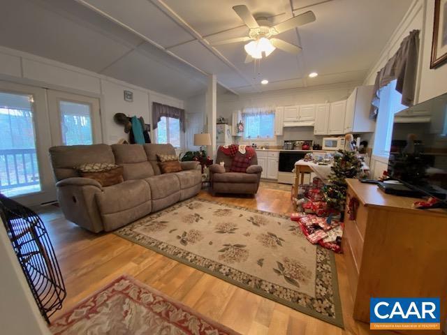 living room with french doors, light wood-type flooring, and ceiling fan