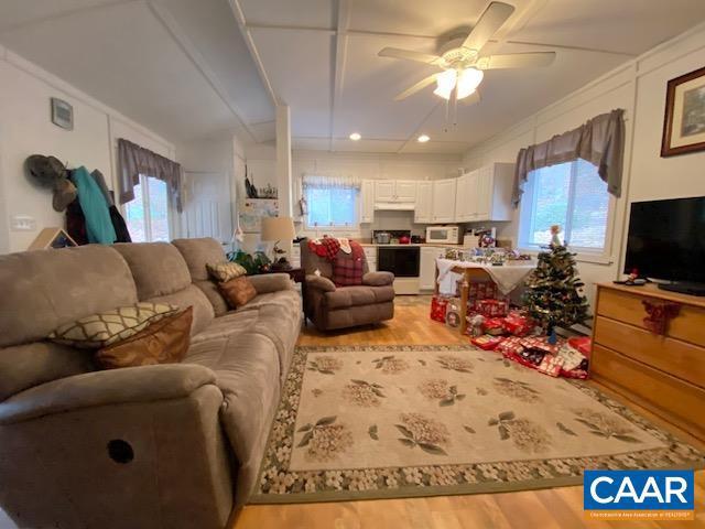 living room with ceiling fan and light wood-type flooring