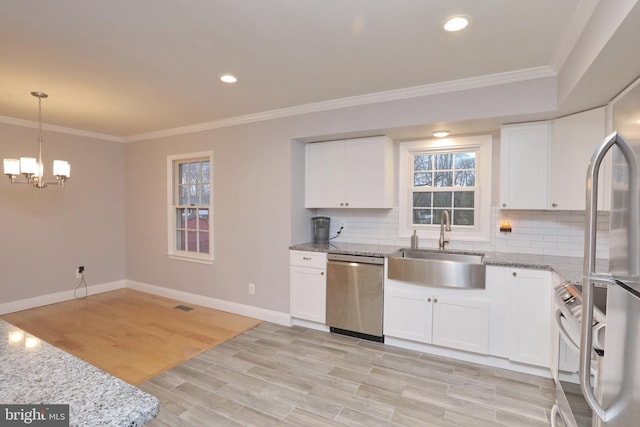 kitchen featuring tasteful backsplash, white cabinets, appliances with stainless steel finishes, and light hardwood / wood-style floors