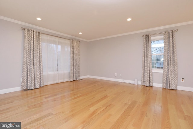 spare room with ornamental molding and light hardwood / wood-style floors