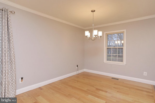 spare room featuring an inviting chandelier, crown molding, and wood-type flooring