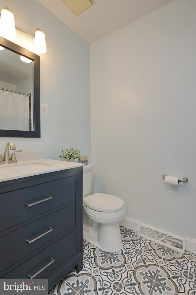 bathroom with toilet, tile patterned flooring, and vanity