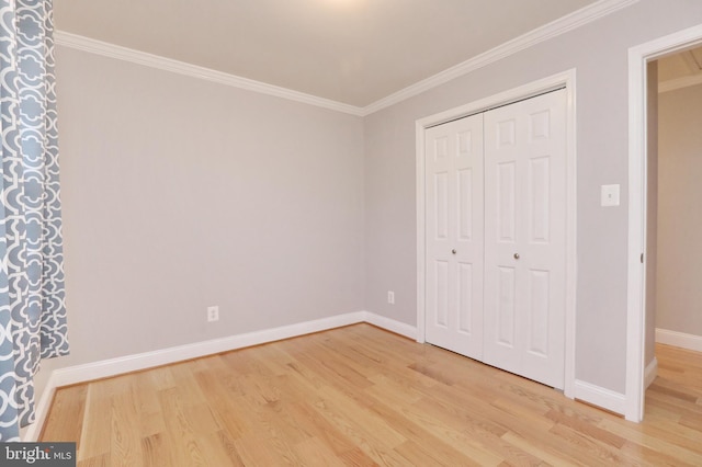 unfurnished bedroom featuring hardwood / wood-style floors, a closet, and crown molding