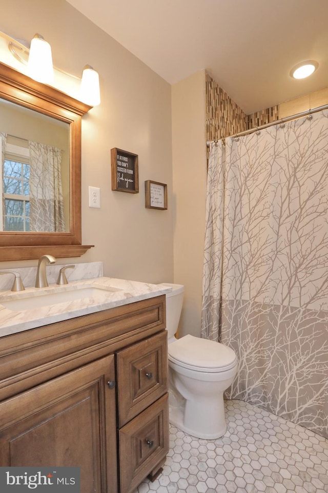 bathroom with toilet, vanity, and tile patterned floors