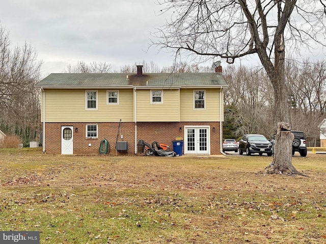 back of property with a yard, central AC unit, and french doors