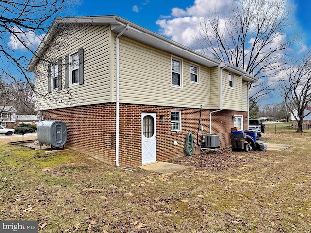 back of house with cooling unit and a yard