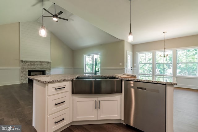 kitchen with dishwasher, dark wood-type flooring, a brick fireplace, lofted ceiling, and white cabinets