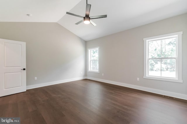 unfurnished room featuring ceiling fan, dark hardwood / wood-style flooring, lofted ceiling, and a wealth of natural light