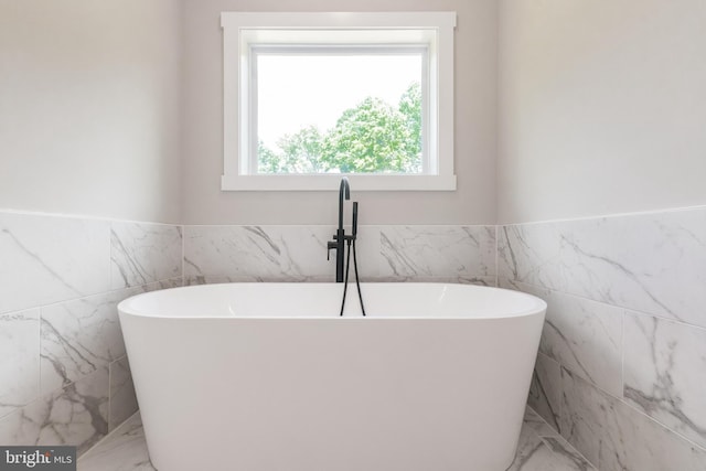 bathroom featuring a tub and tile walls