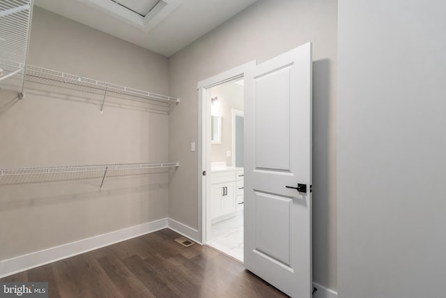 spacious closet with dark hardwood / wood-style flooring