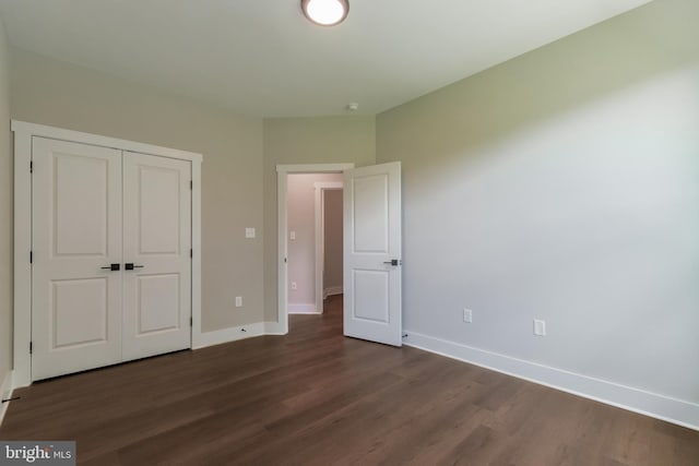 unfurnished bedroom with a closet and dark hardwood / wood-style floors