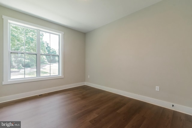 empty room with dark hardwood / wood-style flooring