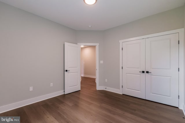 unfurnished bedroom featuring a closet and dark hardwood / wood-style floors