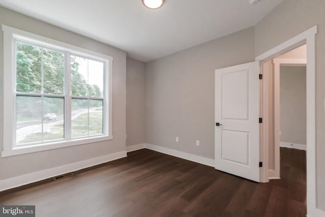 unfurnished room with dark hardwood / wood-style floors