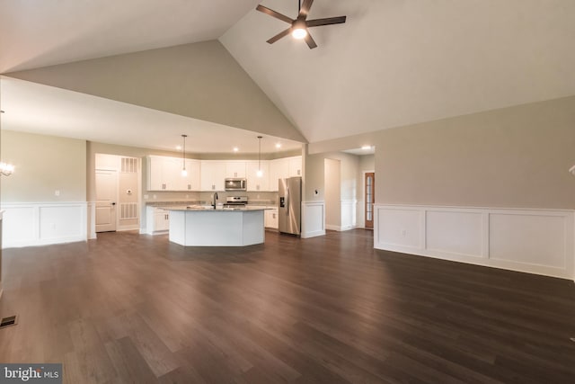 unfurnished living room with ceiling fan with notable chandelier, sink, dark wood-type flooring, and high vaulted ceiling