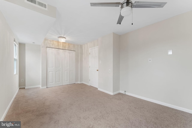 unfurnished bedroom with ceiling fan, carpet floors, and a closet