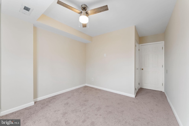 spare room with ceiling fan and light carpet