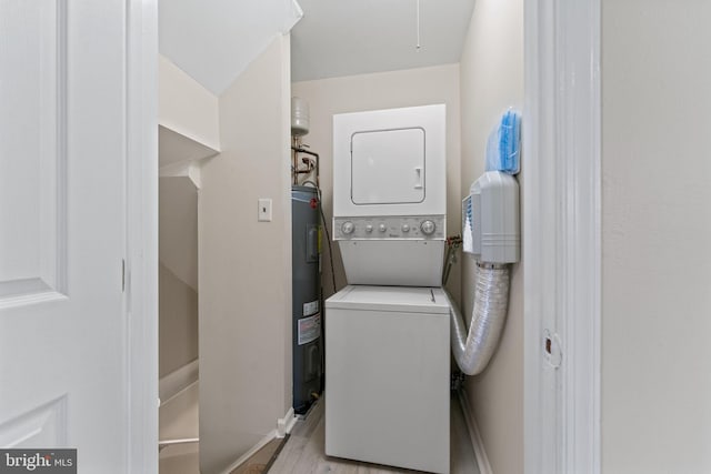 clothes washing area with electric water heater, light hardwood / wood-style floors, and stacked washer and clothes dryer