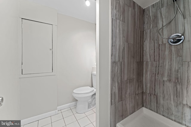 bathroom featuring tile patterned flooring, toilet, and a shower